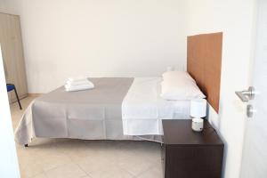 a bedroom with a bed with white sheets and pillows at Catherine Suite in SantʼEufemia Lamezia +6 photos