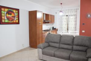 a living room with a couch and a kitchen at Catherine Suite in SantʼEufemia Lamezia