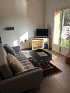 a living room with a couch and a glass coffee table at Charmante petite maison provençale in Grasse