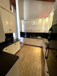 a kitchen with white cabinets and a tile floor at Bo-Kaap Double Room with High Ceiling in Cape Town