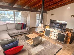 a living room with a couch and a flat screen tv at Bo-Kaap Double Room with High Ceiling in Cape Town