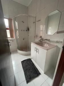 a white bathroom with a sink and a shower at Bo-Kaap Double Room with High Ceiling in Cape Town