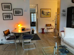 a living room with a table and chairs and a couch at Appartement contemporain Les Tulipes, 2 personnes à 300 m du lac de Gérardmer in Gérardmer