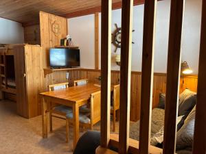 a dining room with a wooden table and a tv at Runneröd in Saltvik