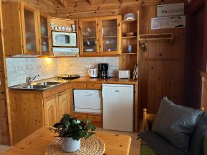 a small kitchen with wooden cabinets and a table at Runneröd in Saltvik
