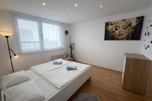 a bedroom with a bed and a painting on the wall at Apartmán MARKI in Malacky