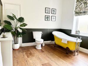 a bathroom with a yellow tub and a toilet at Thorpe House - Fylingthorpe in Fylingthorpe