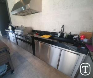 a kitchen with stainless steel appliances and a sink at Quinta La Terquedad in Montemorelos
