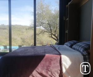 a bed in a bedroom with a large window at Quinta La Terquedad in Montemorelos +33 photos
