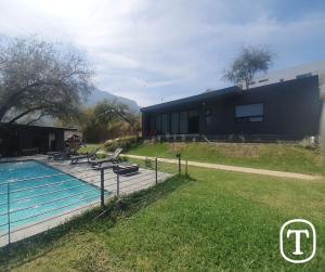 a house with a swimming pool next to a building at Quinta La Terquedad in Montemorelos