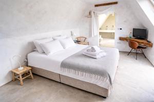 a white bedroom with a bed and a desk at Plockton Shoreside House in Plockton