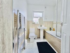 a bathroom with a toilet and a sink and a tub at Room 3 Shared House in Bootle in Litherland
