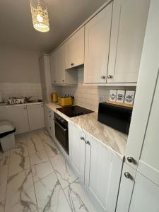a kitchen with white cabinets and a counter top at Belles Haven in Belfast