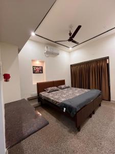 a bedroom with a bed and a ceiling fan at Vishwageeta 2 in Mangalore