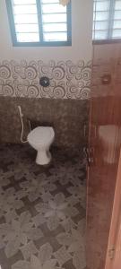 a bathroom with a toilet and a shower at Vishwageeta 2 in Mangalore