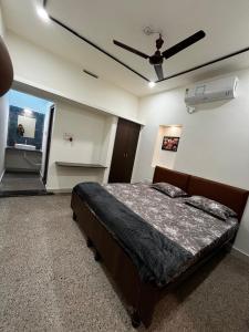 a bedroom with a bed and a ceiling fan at Vishwageeta 2 in Mangalore
