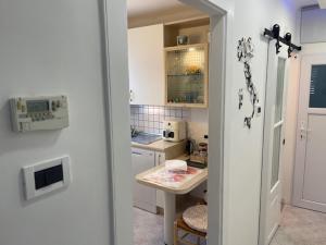 a small kitchen with a table and a refrigerator at 20 a Trieste in Trieste +11 photos