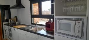 a kitchen with a sink and a microwave at Casa Rural Solterra in Roa +7 photos