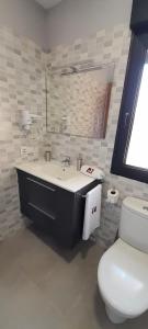 a bathroom with a white toilet and a sink at Casa Rural Solterra in Roa