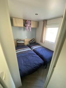 two beds in a small room with a teddy bear at mon paradis in Lattes
