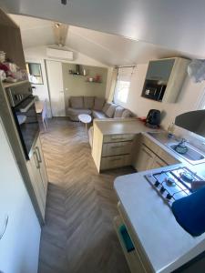 a kitchen and living room with a couch and a table at mon paradis in Lattes