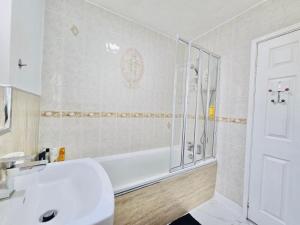 a bathroom with a tub and a sink and a shower at Room 2 Shared House in Bootle in Litherland
