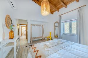 a white bedroom with a large bed and a mirror at Casa do Arlindo in São Bartolomeu de Messines +16 photos