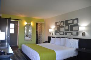 Habitación de hotel con cama grande y espejo en University Inn ASU/Tempe en Tempe