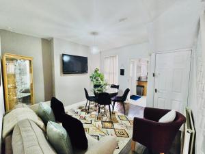 a living room with a couch and a table and chairs at Room 1 Shared House in Bootle in Litherland +13 photos