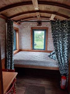 a bed in a tiny house with a window at EcoPod Holidays in Alton +68 photos