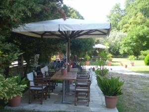 a wooden table and chairs under an umbrella at Dodis Village in Platanias