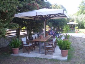 a wooden table and chairs under an umbrella at Dodis Village in Platanias