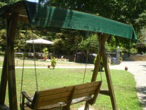 a swing in a park with a green canopy at Dodis Village in Platanias