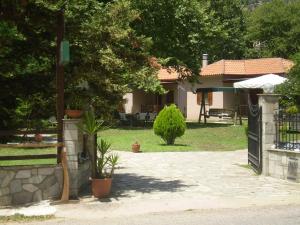 a house with a gate and a yard with a patio at Dodis Village in Platanias
