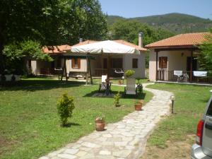 a house with a patio and a table with an umbrella at Dodis Village in Platanias