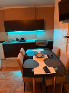 a kitchen with a table with chairs and blue lights at Apartman 23 in Belgrade