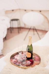 a table with two glasses and a bottle of wine at Ulvsby Ranch Glamping in Karlstad