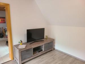 a flat screen tv sitting on top of a wooden entertainment center at FeWo Glücksmoment in Idar-Oberstein