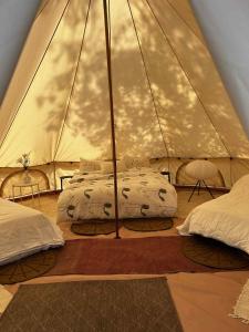a bedroom with two beds in a tent at Ulvsby Ranch Glamping in Karlstad