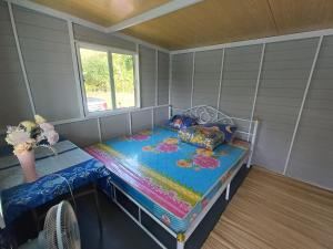 a small room with a bed and a window at S&A Camping in Ban Kum