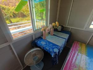 a small room with a table and a window at S&A Camping in Ban Kum