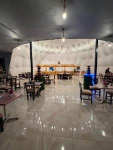 a dining area with tables and chairs in a tent at Rina Luxury Camp in Wadi Rum