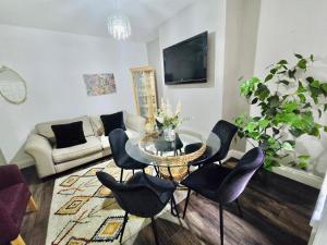 a living room with a glass table and black chairs at Room 1 Shared House in Bootle in Litherland