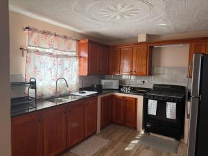 a kitchen with wooden cabinets and a sink and a stove at Rawacou Breeze in Kingstown