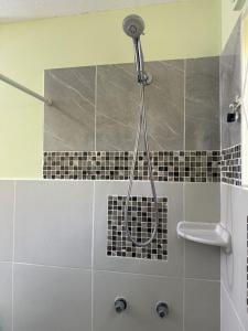 a shower in a bathroom with black and white tiles at Rawacou Breeze in Kingstown