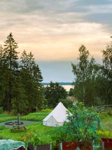 a white tent and a picnic table in a field at Ulvsby Ranch Glamping in Karlstad