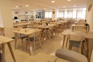 a restaurant with wooden tables and chairs and a kitchen at Muthu La Perla Tenerife in Puerto de la Cruz