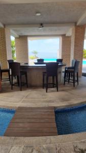 a room with a table and chairs and a pool at PREMIUM Puerto Varadero Apartamento con Vista al Mar y Planta Total in Tucacas
