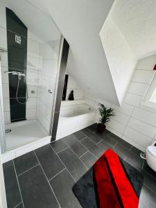 a bathroom with a shower and a bath tub at Heimglück mit Ipf & Ruine in Bopfingen +25 photos
