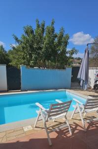 two chairs and an umbrella next to a swimming pool at Da Anna Casa Vacanza Al Mare in Santa Lucia